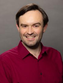 Photo of Tim Hogue, 3/4 view in red shirt